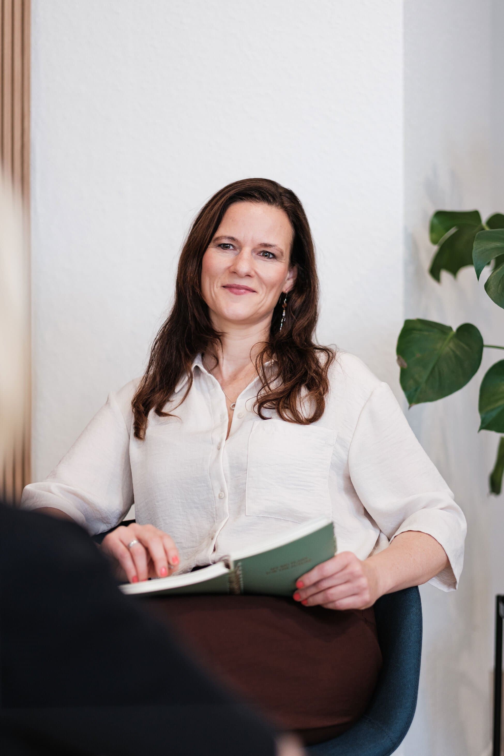 Ariane Grebenstein mit Notizbuch im Beratungsraum