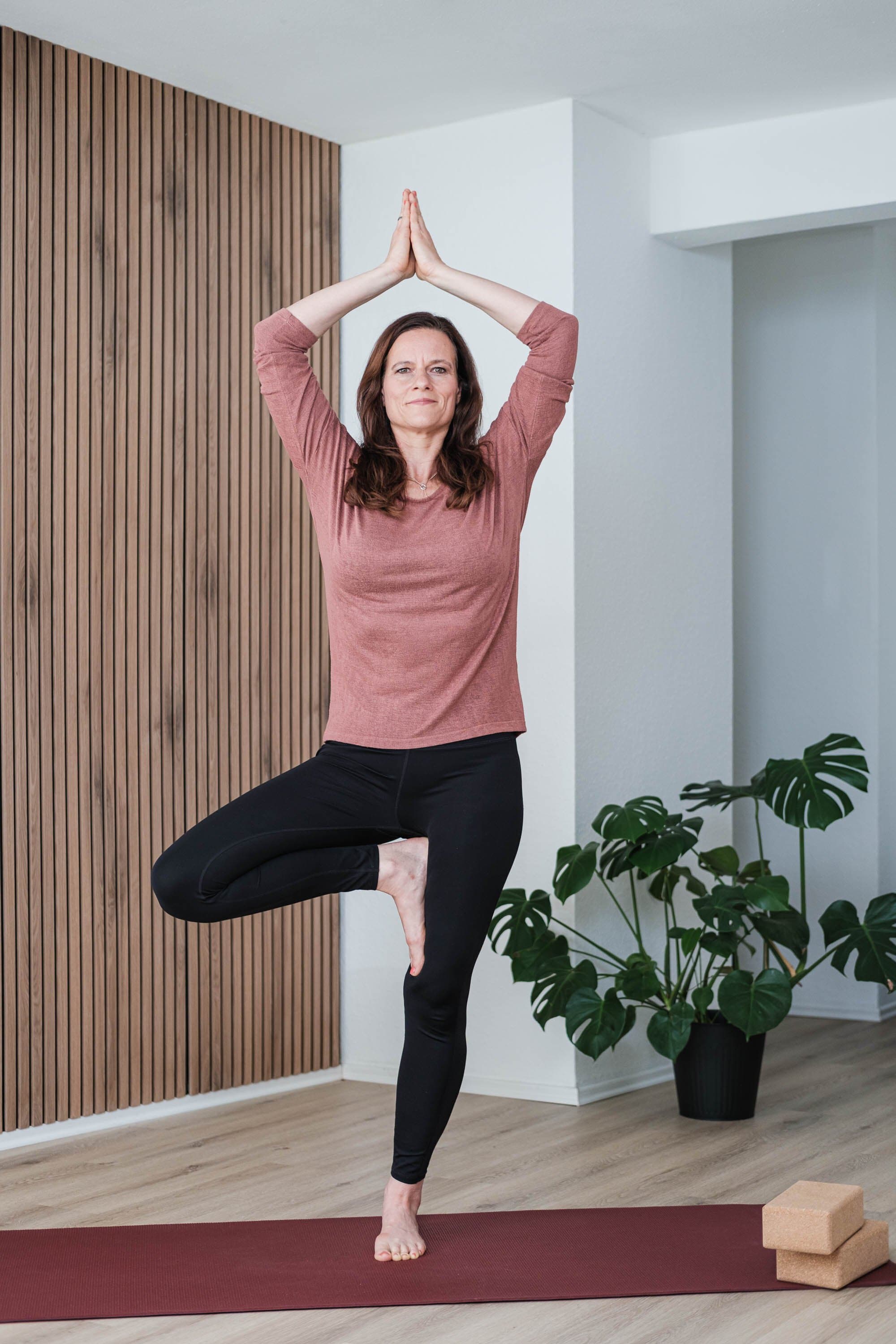 Ariane Grebenstein in der Baumhaltung auf einer Yogamatte