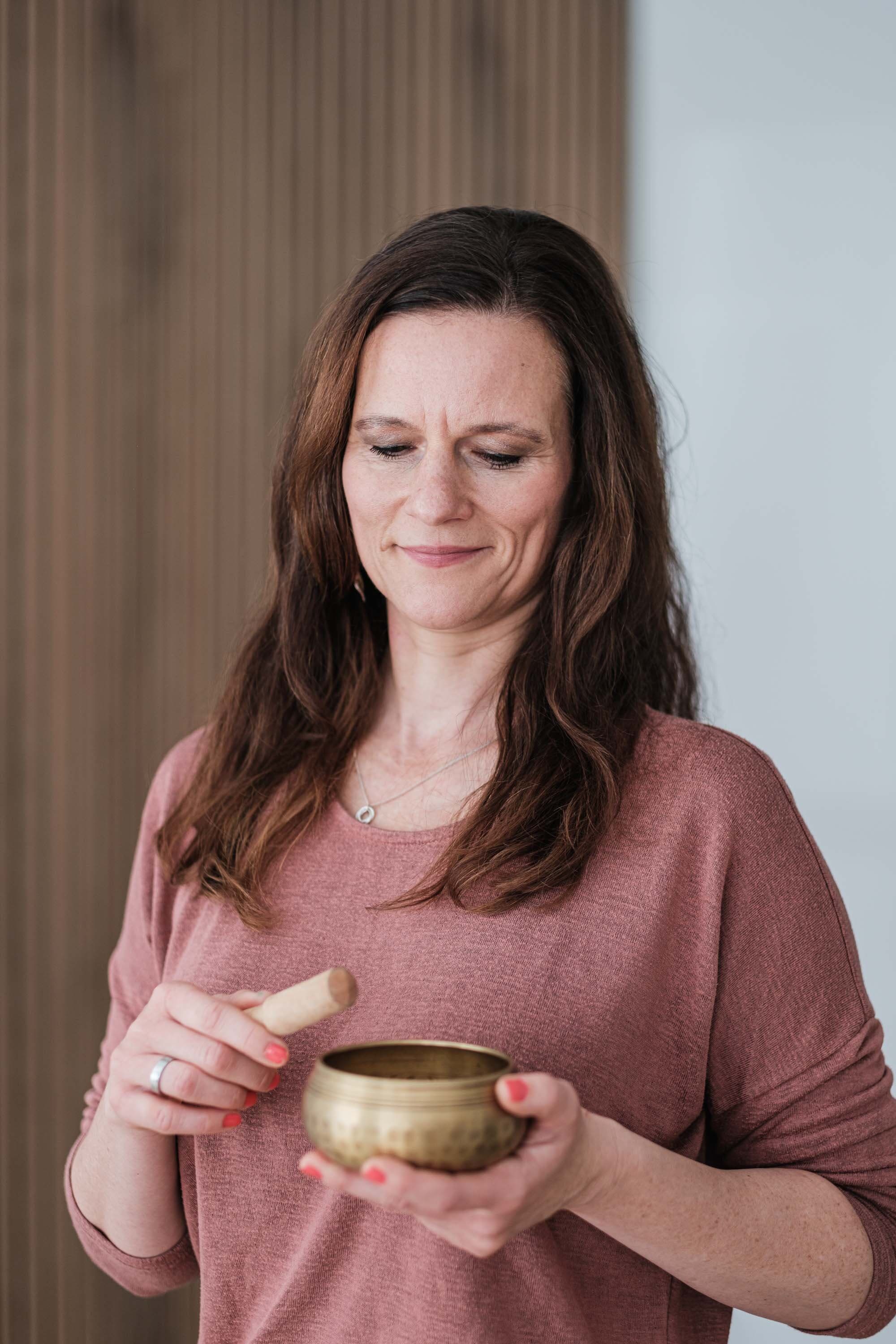 Ariane Grebenstein mit einer Klangschale im Studio