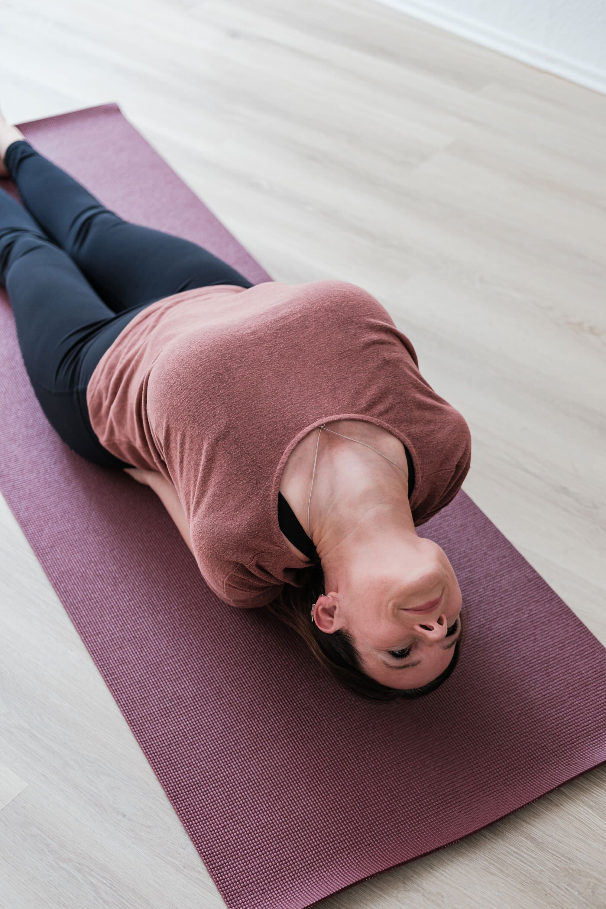 Ariane Grebenstein liegend in einer entspannenden Yogaposition